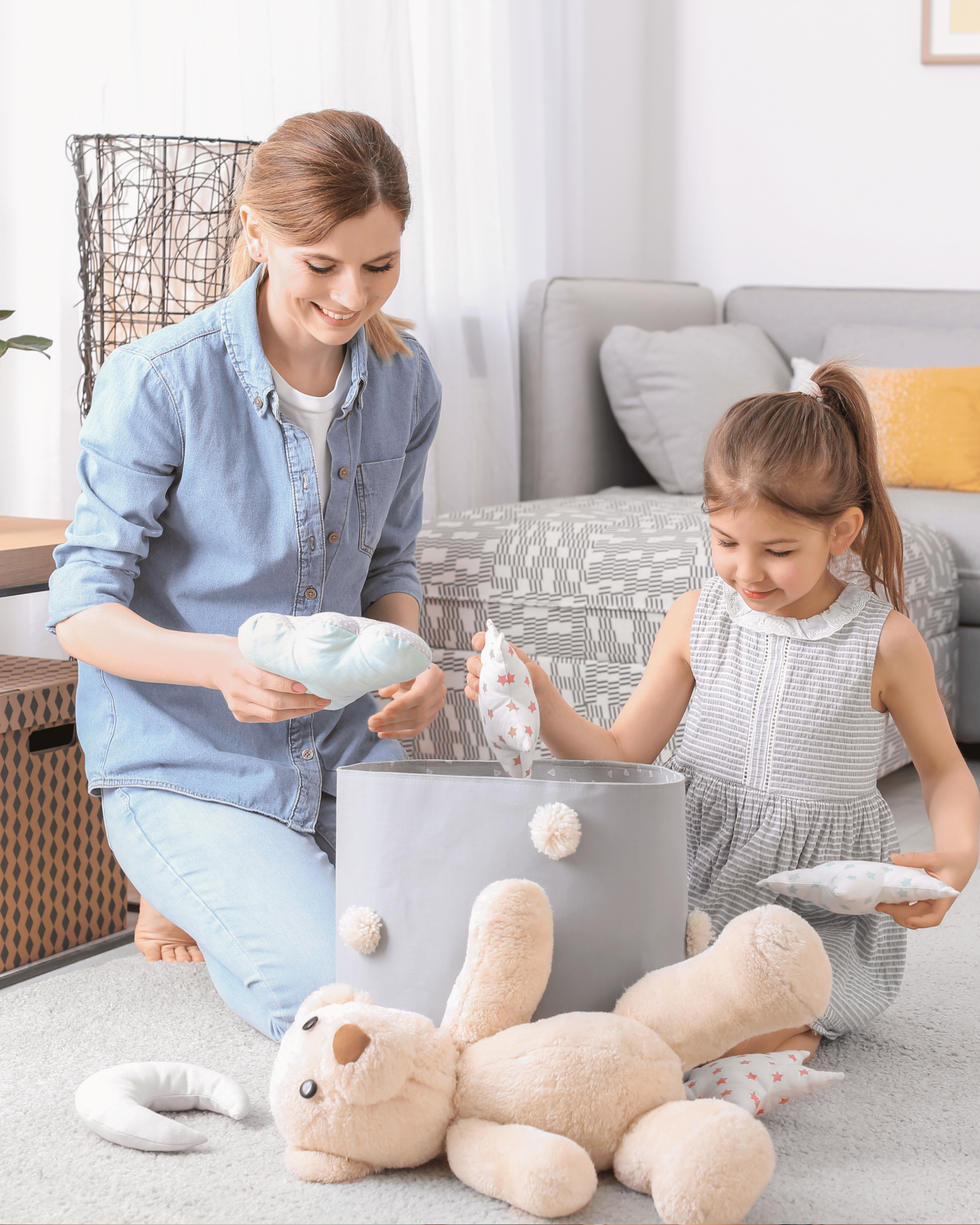 Woman and child playing with toys on a living room floor